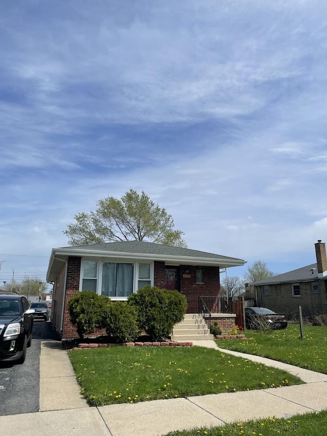 view of front facade featuring brick siding, a front lawn, and a porch