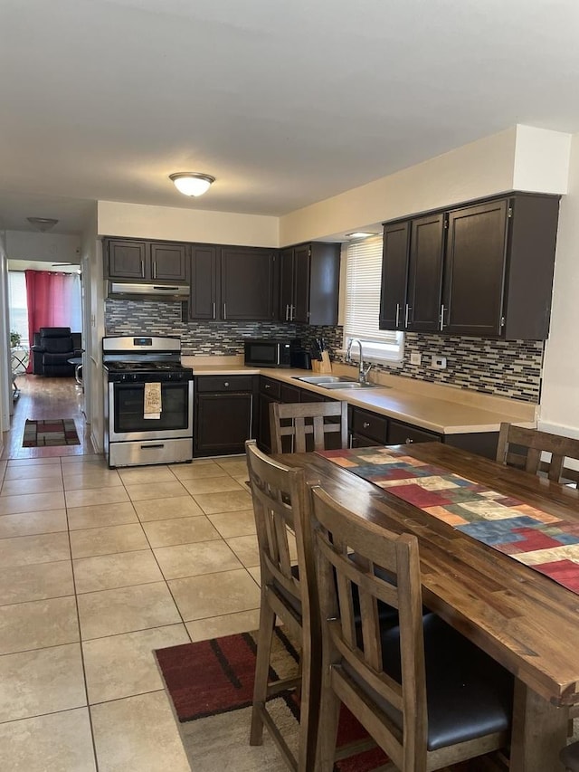 kitchen with light countertops, backsplash, and stainless steel gas range