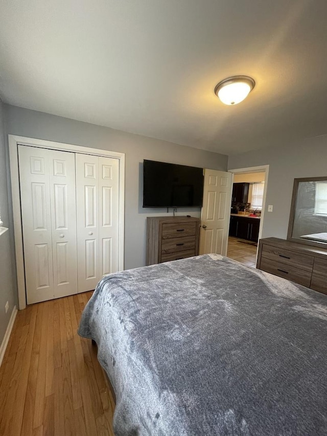 bedroom featuring a closet, baseboards, and wood finished floors