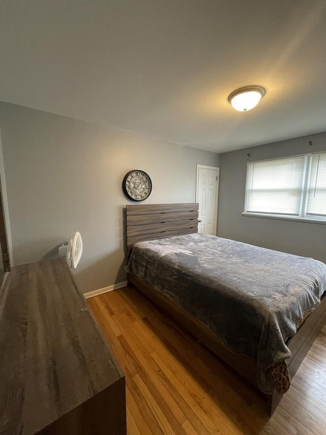 bedroom with baseboards and wood finished floors