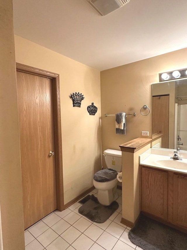 bathroom featuring vanity, tile patterned flooring, and toilet