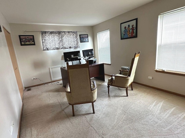 office area featuring baseboards, visible vents, and light colored carpet