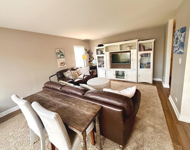 living area with baseboards and dark wood-style floors
