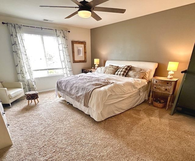 bedroom with ceiling fan, visible vents, light carpet, and baseboards