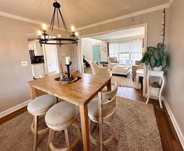 dining space featuring baseboards, ornamental molding, dark wood-style floors, and a notable chandelier