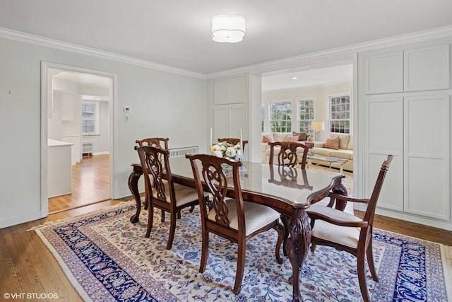 dining area with crown molding, light wood-style flooring, and baseboards