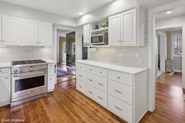 kitchen with backsplash, appliances with stainless steel finishes, light countertops, dark wood-style floors, and white cabinetry