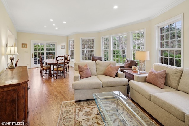 living room with recessed lighting, ornamental molding, and light wood-style flooring