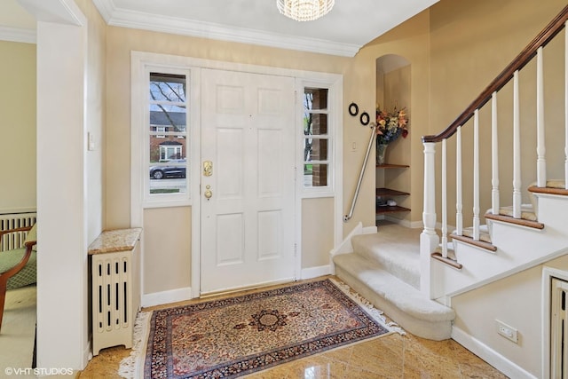 entrance foyer featuring arched walkways, baseboards, ornamental molding, and stairway
