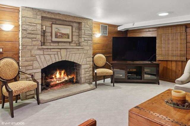 living area with wooden walls, a fireplace, and visible vents