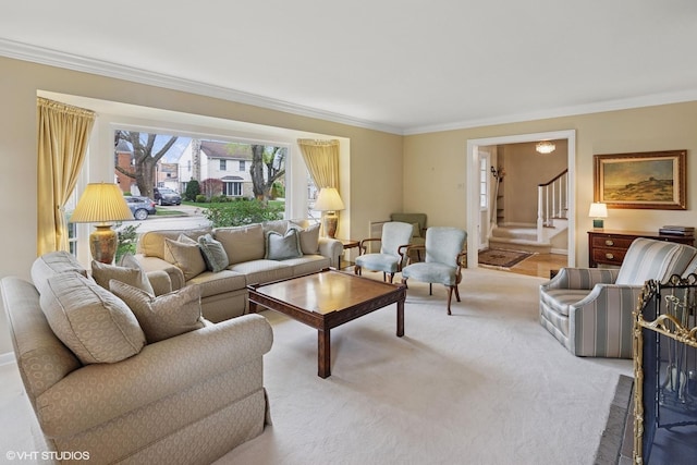 living room featuring carpet floors, baseboards, ornamental molding, and stairway