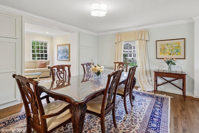 dining room with baseboards, ornamental molding, and wood finished floors