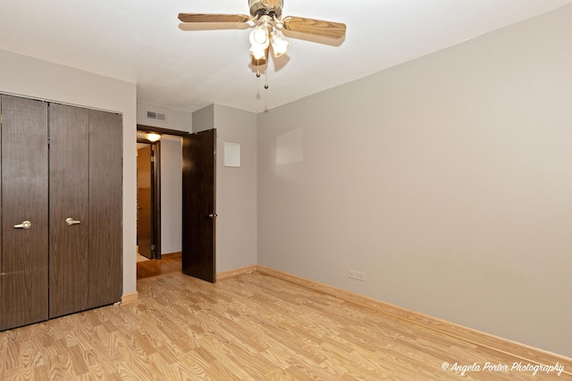 unfurnished bedroom with ceiling fan, baseboards, light wood-type flooring, visible vents, and a closet