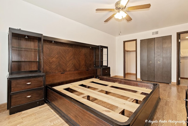 unfurnished bedroom with a ceiling fan, light wood-style flooring, and visible vents