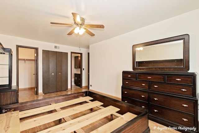 bedroom with baseboards, visible vents, ceiling fan, and wood finished floors