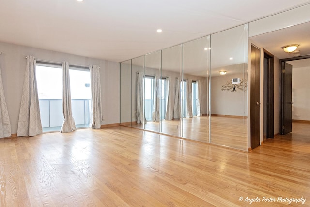 spare room featuring baseboards, a healthy amount of sunlight, and wood finished floors