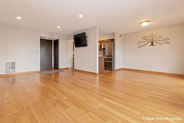 empty room featuring visible vents, recessed lighting, light wood finished floors, and baseboards