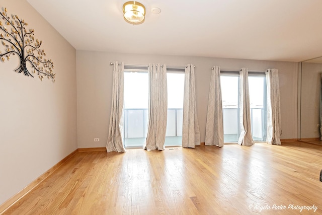 empty room with baseboards and light wood finished floors