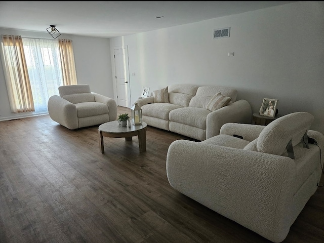 living area with dark wood-style flooring and visible vents