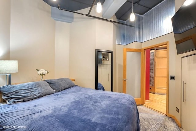 bedroom with a high ceiling and light wood-type flooring