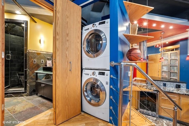 washroom with laundry area, stacked washer / dryer, tile walls, wainscoting, and beverage cooler