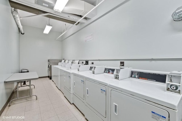 shared laundry area with washer and dryer and baseboards