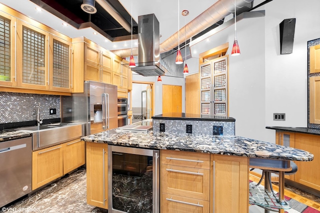 kitchen featuring appliances with stainless steel finishes, tasteful backsplash, a center island, beverage cooler, and glass insert cabinets