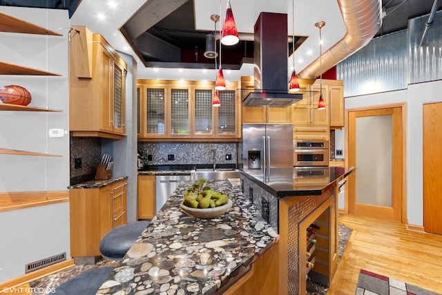 kitchen with backsplash, visible vents, appliances with stainless steel finishes, a sink, and light wood-style floors