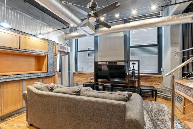 living room with a ceiling fan and light wood-style flooring
