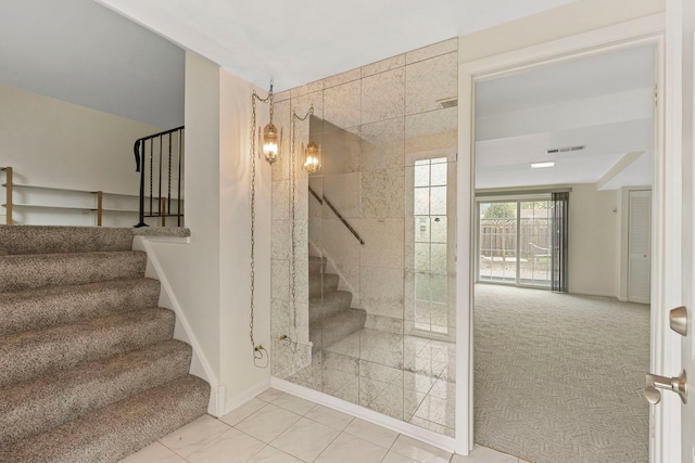stairway featuring baseboards, carpet flooring, tile patterned floors, and visible vents