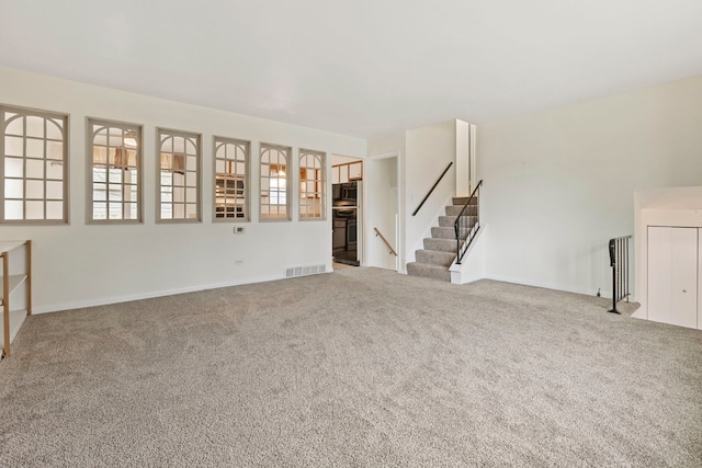 unfurnished living room featuring stairway, carpet floors, baseboards, and visible vents