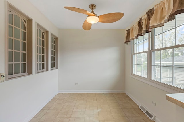 spare room with a ceiling fan, baseboards, and visible vents