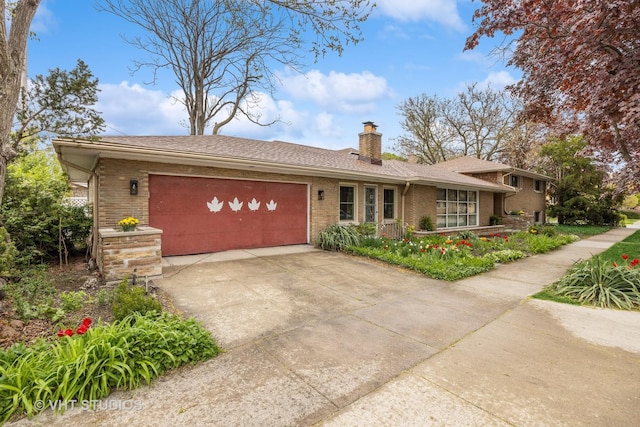 view of front facade featuring brick siding, an attached garage, driveway, and a chimney