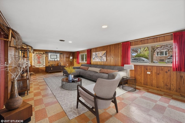 living room featuring tile patterned floors, wood walls, and plenty of natural light