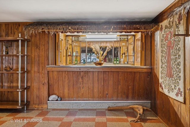 interior space with tile patterned floors and wood walls