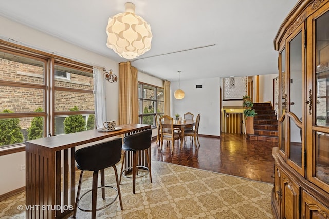dining space featuring baseboards and stairs
