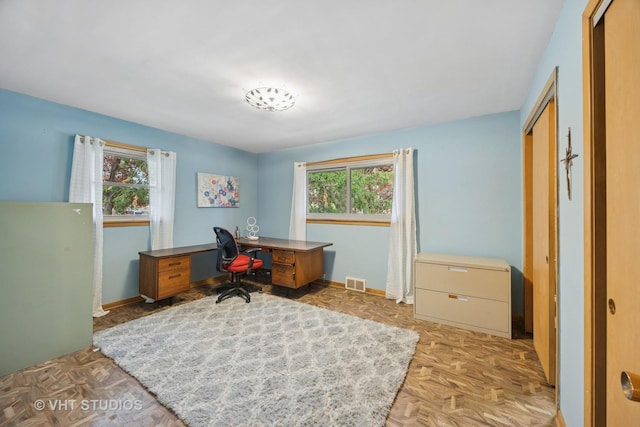 office space with a healthy amount of sunlight, baseboards, and visible vents