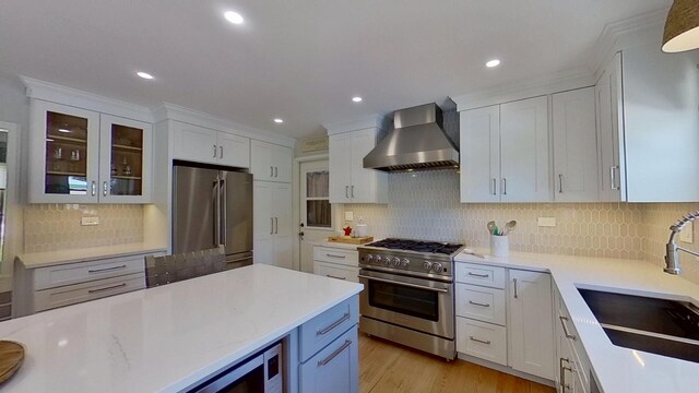 1938 Keim Dr, Wheaton, IL 60189 - kitchen with wall chimney range hood, premium appliances, a sink, white cabinets, and tasteful backsplash