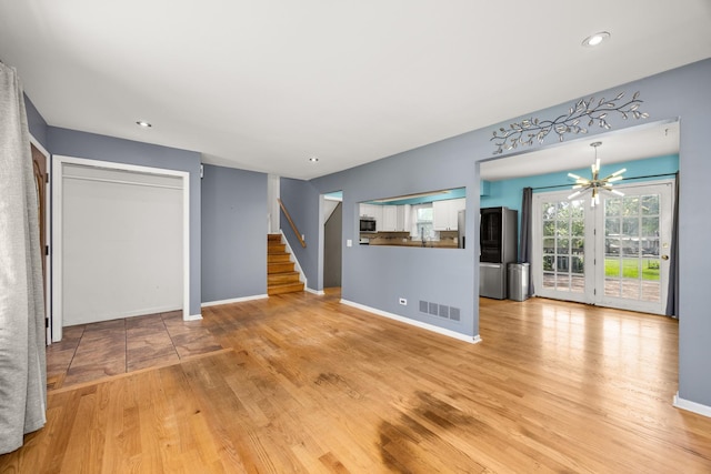 28W521 Donald Ave, West Chicago, IL 60185 - unfurnished living room with stairway, light wood-type flooring, recessed lighting, and a chandelier