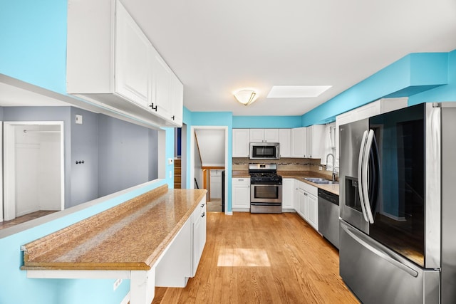 28W521 Donald Ave, West Chicago, IL 60185 - kitchen with appliances with stainless steel finishes, white cabinets, light wood-type flooring, light countertops, and a peninsula
