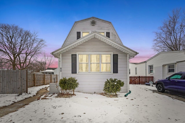 view of front of property featuring fence and a gambrel roof