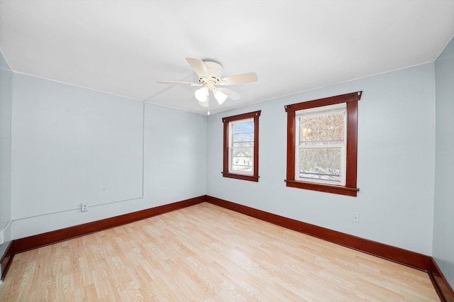 empty room with a ceiling fan, wood finished floors, and baseboards