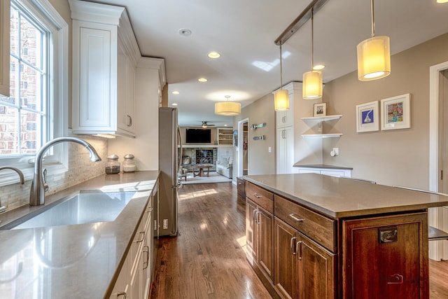 kitchen featuring freestanding refrigerator, white cabinetry, dark wood-style flooring, a sink, and recessed lighting