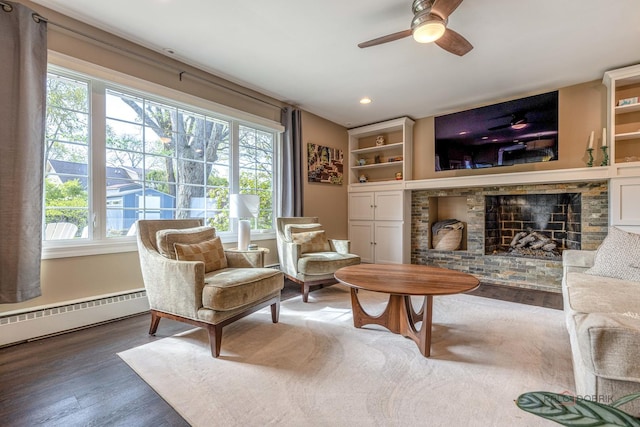sitting room featuring a brick fireplace, wood finished floors, ceiling fan, recessed lighting, and a baseboard radiator