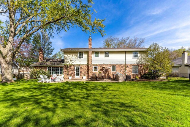 rear view of house with a chimney and a patio