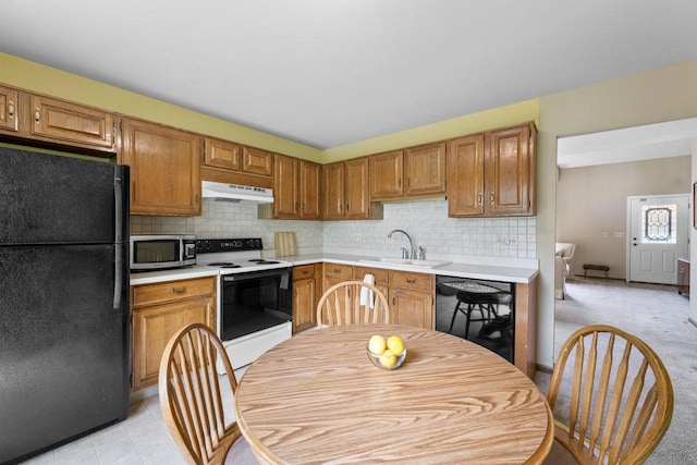 3038 Ashton Ct, Westchester, IL 60154 - kitchen featuring decorative backsplash, a sink, light countertops, black appliances, and under cabinet range hood