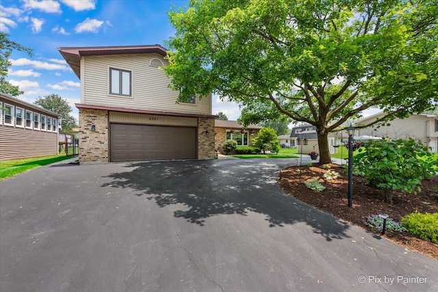 6561 Dunham Rd, Downers Grove, IL 60515 - view of front of house with brick siding, asphalt driveway, and a garage
