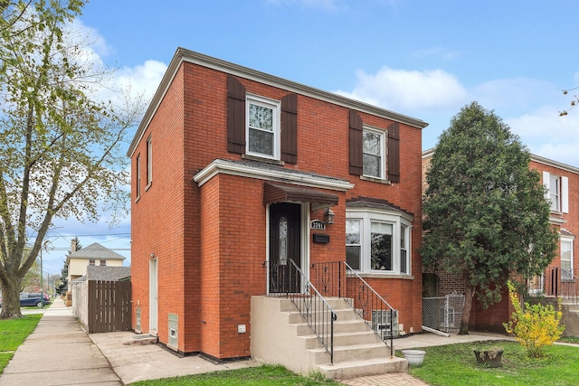 traditional-style home with brick siding and fence