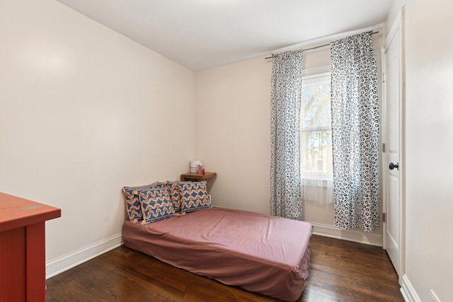 bedroom with baseboards and wood finished floors
