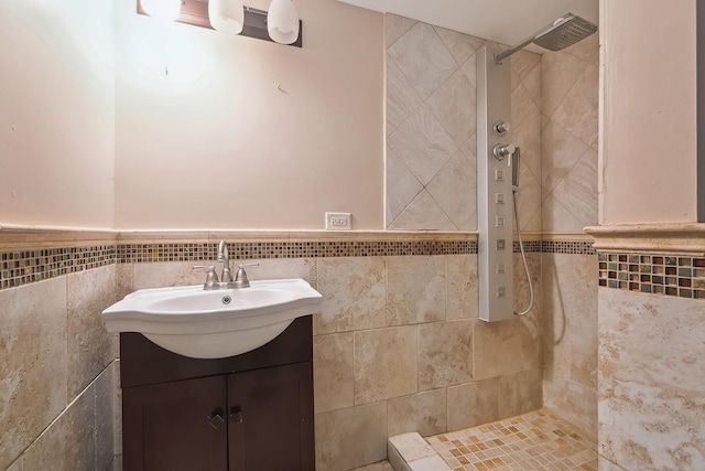 bathroom with vanity, tiled shower, and tile walls
